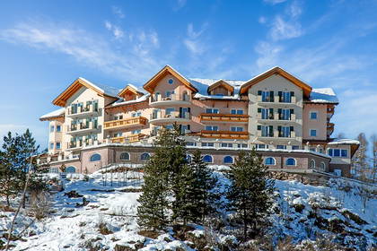 Hotel w stylu alpejskim na ośnieżonym wzgórzu.
