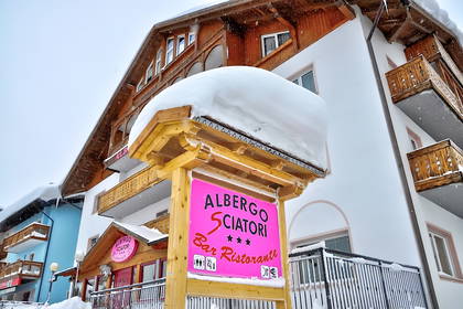 Zimowy widok na hotel "Albergo Sciatori" spod śniegu.