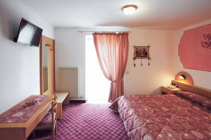 Pokój hotelowy z łóżkiem, biurkiem i telewizorem.