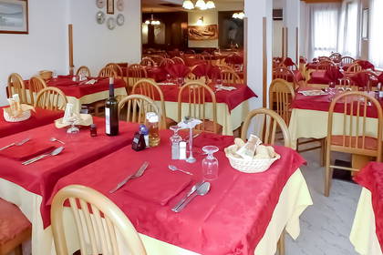 Wnętrze restauracji z zastawionymi stołami.