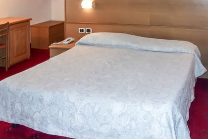 Pokój hotelowy z dużym łóżkiem i drewnianymi meblami.