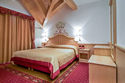 Pokój hotelowy z łóżkiem i drewnianymi elementami wystroju.