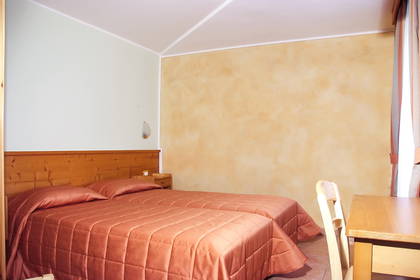 Pokój hotelowy z dwoma łóżkami i drewnianym biurkiem.