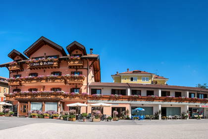Hotel i salon fryzjerski z balkonami ukwieconymi kwiatami.
