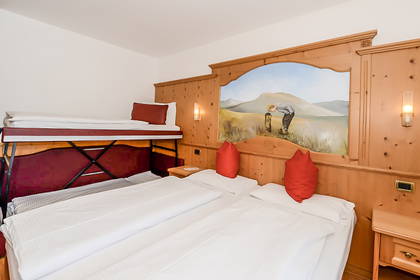 Pokój hotelowy z łóżkiem piętrowym i ścianą wyłożoną drewnem.