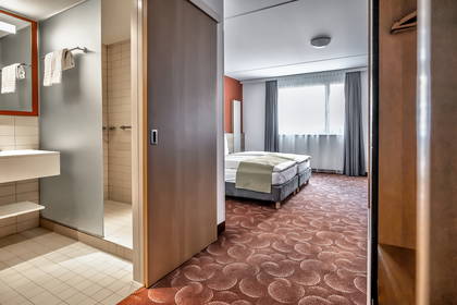 Pokój hotelowy z łazienką i widokiem na łóżko.