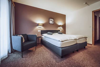 Pokój hotelowy z łóżkiem typu queen-size i krzesłem.
