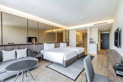 Pokój hotelowy z dwoma łóżkami, sofą i łazienką.