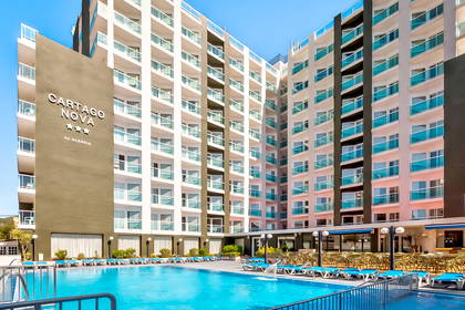 Nowoczesny hotel Cartago Nova z basenem i leżakami w słoneczny dzień.