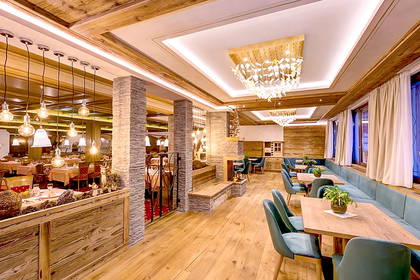 Wnętrze restauracji z drewnianymi detalami i ozdobnym oświetleniem.