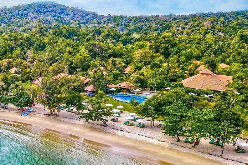 Kurort na plaży otoczony zielenią, widok z góry.