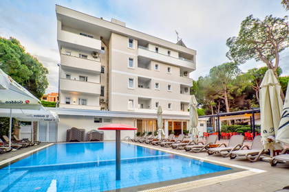 Basen z leżakami przy hotelu.