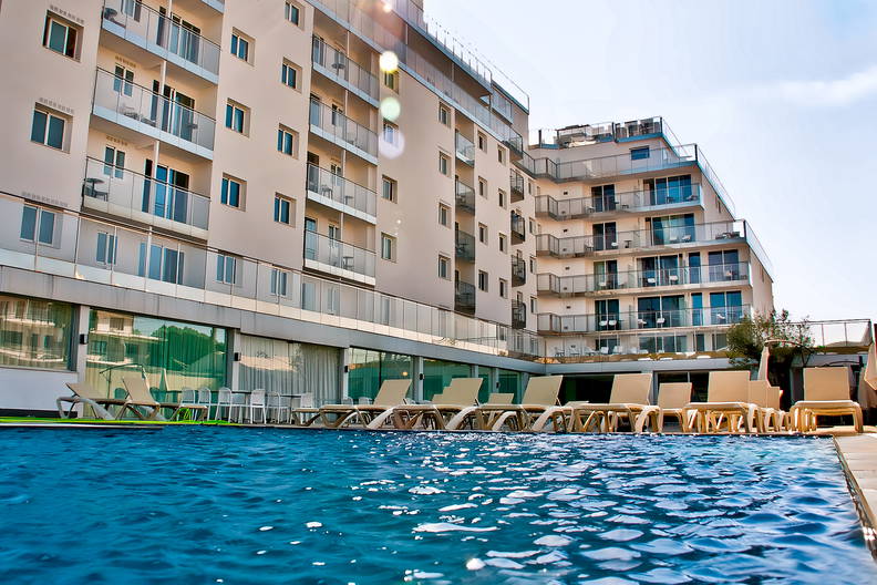 Basen z leżakami przy hotelu.