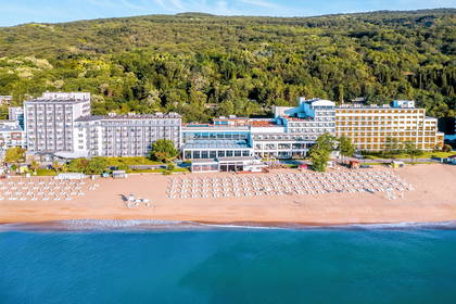 Widok z lotu ptaka na hotel z plażą i leżakami nad morzem.