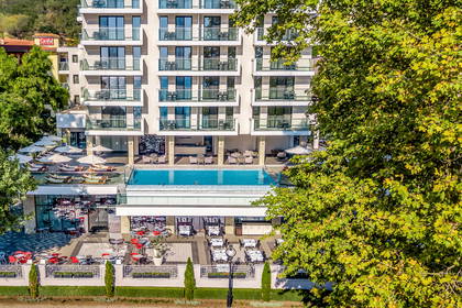 Hotel z basenem, tarasem i balkonami.