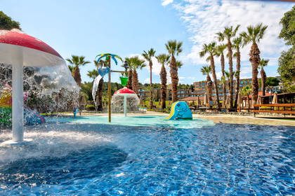 Aquapark z palmami i atrakcjami wodnymi.