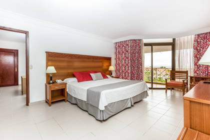 Pokój hotelowy z dużym łóżkiem i balkonem.