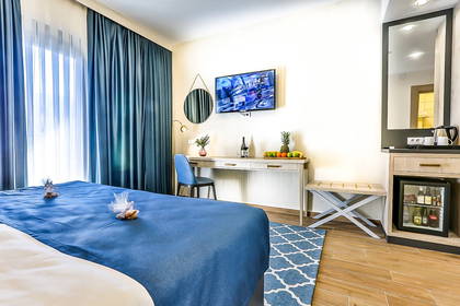 Pokój hotelowy z niebieskimi zasłonami i pościelą.