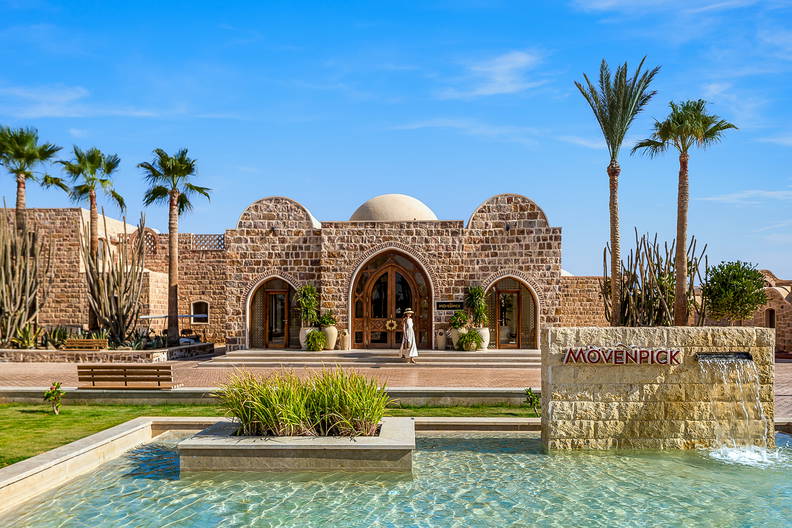 Hotel Mövenpick z elementami kamiennymi i palmami.