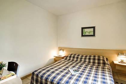 Pokój hotelowy z łóżkiem, szafką nocną i krzesłem.