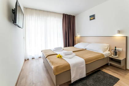Pokój hotelowy z dużym łóżkiem i telewizorem.