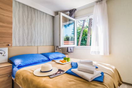 Jasny pokój hotelowy z łóżkiem i otwartym oknem.