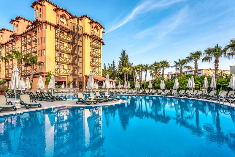 Hotel z basenem i leżakami do opalania.