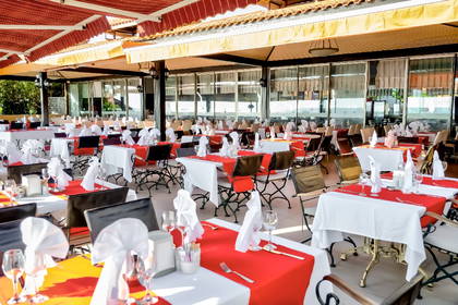 Restauracja na zewnątrz z nakrytymi stołami.