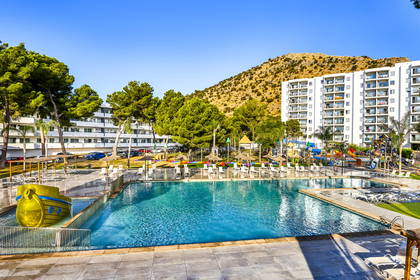 Basen hotelowy z atrakcjami wodnymi. W tle budynki.