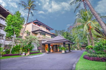 Hotel otoczony tropikalną roślinnością i palmami.