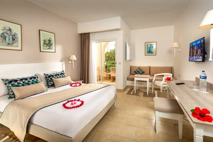 Pokój hotelowy z łóżkiem, biurkiem i balkonem.