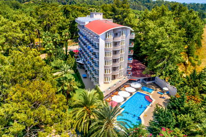 Hotel z basenem otoczony zielenią, widok z góry.