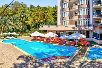 Hotel z basenem, parasolami i leżakami do opalania.