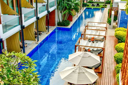 Basen hotelowy z leżakami i parasolami, widok z góry.