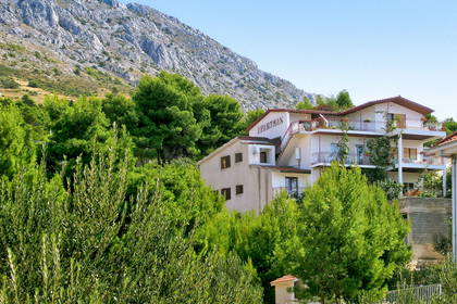 Hotel "Apartman" na tle gór i zieleni.