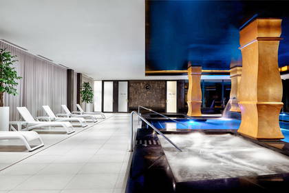 Basen w spa z leżakami do wypoczynku.