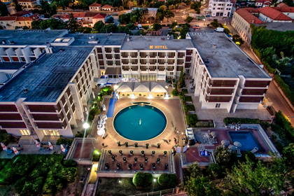 Hotel z basenem nocą, widok z lotu ptaka.