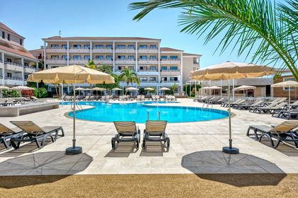 Basen z leżakami i parasolami przy hotelu.