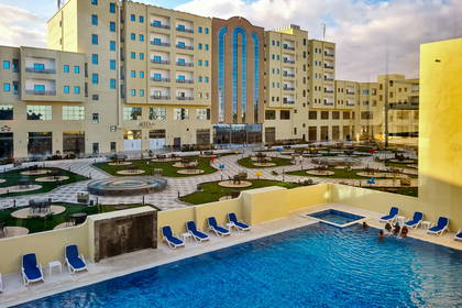 Hotel z basenem i leżakami.