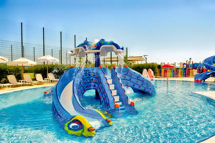 Aquapark z kolorowymi zjeżdżalniami i basenem.