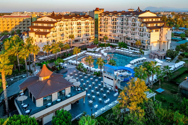 Luksusowy hotel z basenem i palmami, widok z lotu ptaka.