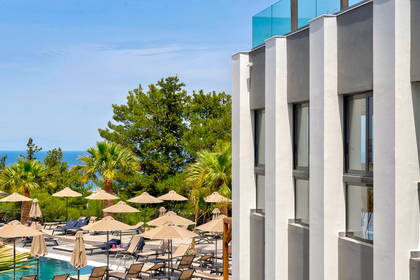 Basen hotelowy z leżakami i parasolami.
