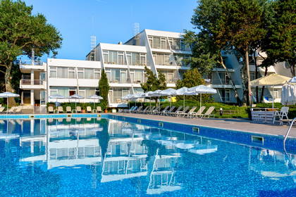 Basen hotelowy z leżakami i parasolami.