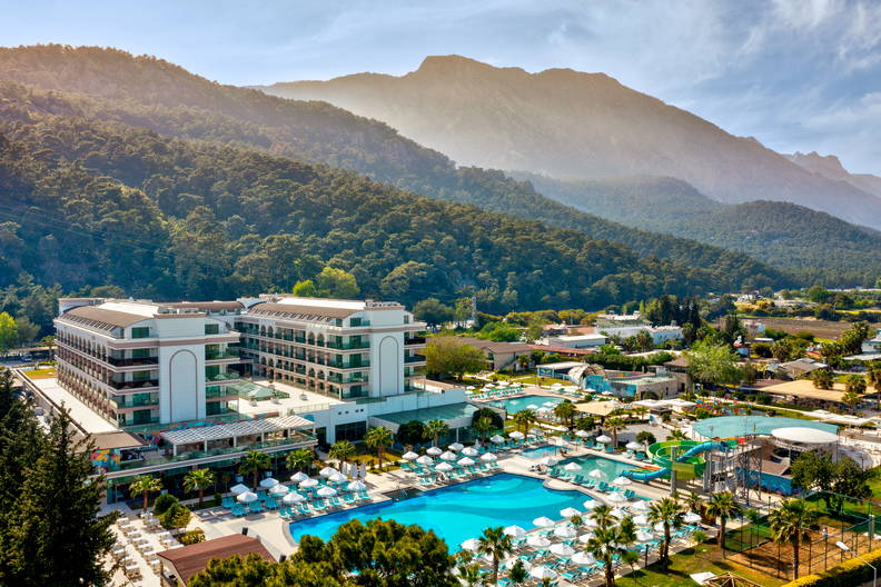 Luksusowy hotel z basenami na tle gór.