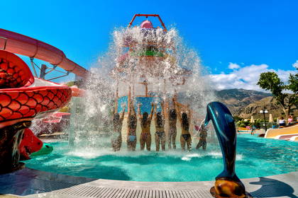 Aquapark z gośćmi pod wodną konstrukcją.