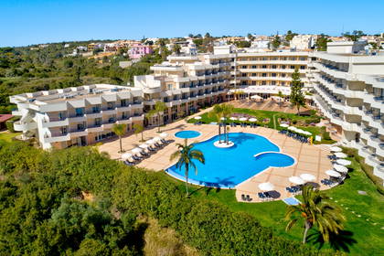 Hotel z basenem i palmami, widok z lotu ptaka.