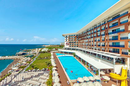 Luksusowy hotel z basenem przy plaży i morzu.