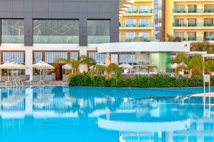Basen hotelowy z barem i leżakami.