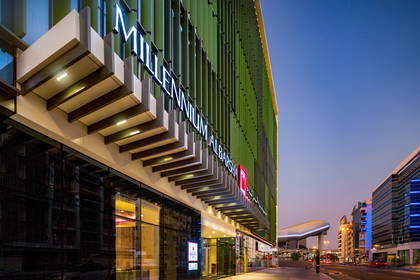 Hotel Millennium Al Barsha o zmierzchu – widok z zewnątrz.