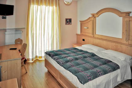 Pokój hotelowy z łóżkiem, biurkiem i telewizorem.